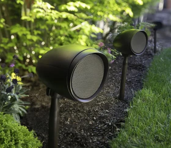 Outdoor Triad speakers in a landscaped garden.
